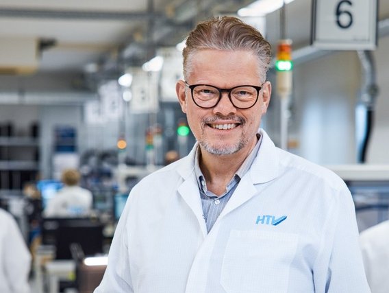 male professional in an lab coat holding documents