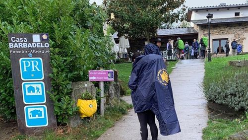 Menschen pilgern in grünen Bademänteln durch die Stadt