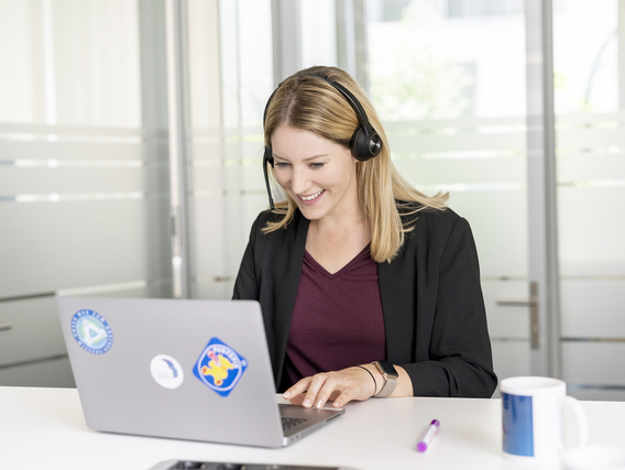 Teaser_IDE_Podcast Woman at a laptop, wearing a headset